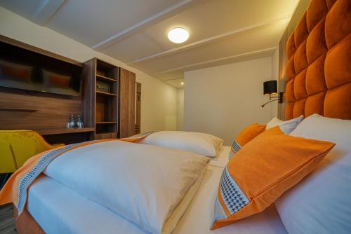 a bedroom with two beds and an orange headboard at Zentrum Hotel Stade in Stade