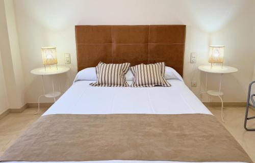 ein Schlafzimmer mit einem großen weißen Bett mit zwei Tischen in der Unterkunft Wallada Vistalegre in Córdoba