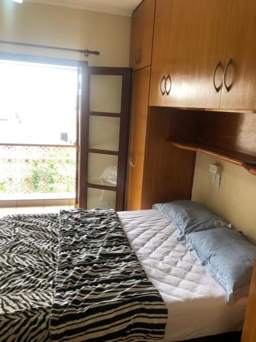 a bedroom with a bed with a zebra patterned blanket at Quarto com varanda tipo Airbn b Vista Panorâmica Livre da Cidade in Americana