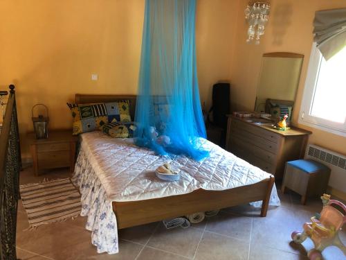 Un dormitorio con una cama con una cortina azul. en Villa Melpo en Likodhrómion