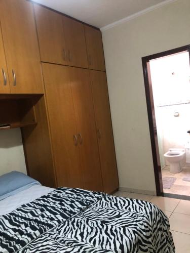 a bedroom with a zebra print bed and a bathroom at Quarto com varanda tipo Airbn b Vista Panorâmica Livre da Cidade in Americana