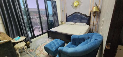 um quarto com uma cama e uma cadeira azul em 樂南居 em Tainan