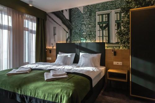 Una habitación de hotel con una cama con toallas. en Oliva Hotel, en Veszprém