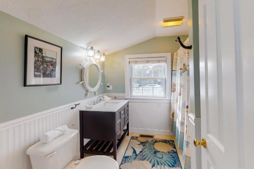 a bathroom with a sink and a toilet and a mirror at Onset Grove in Onset