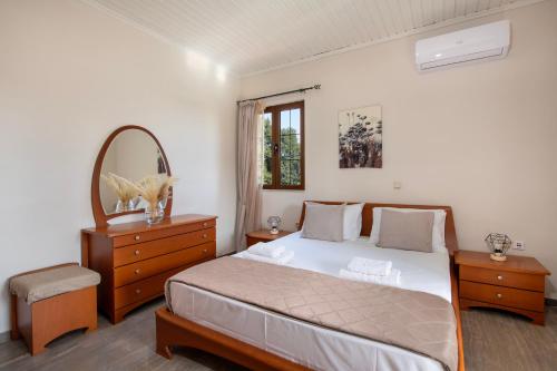 a bedroom with a bed and a mirror and a dresser at Villa Alex with private pool and jacuzzi in Prinés