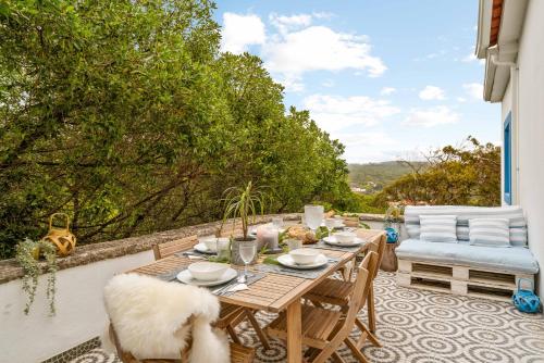 a patio with a table and chairs on a balcony at Familienparadies nahe Strand - Baumhaus & Tiere in Colares