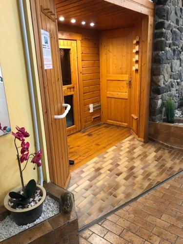 a hallway with a wooden door and a vase with a plant at Waldblick - Bad Harzburg inklusive Schwimmbad und Sauna in Bad Harzburg