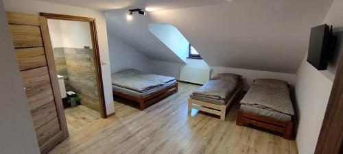 a small room with two beds and a mirror at Pokoje u Juroszka in Istebna