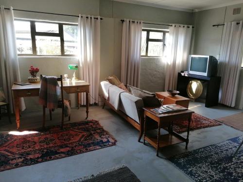 a living room with a couch and a tv at Pied Cow Cottage in Hilton