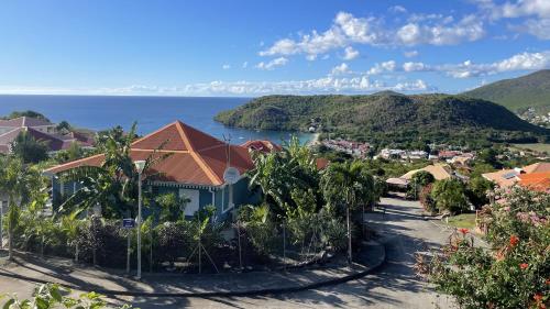 un complexe avec vue sur l'océan et une ville dans l'établissement Villa de charme avec piscine et magnifique vue mer, à Les Anses-d'Arlet