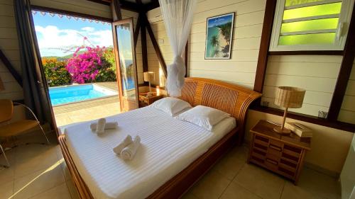 Villa de charme avec piscine et magnifique vue mer في لو أنسيه دو أرليتز: غرفة نوم عليها سرير وفوط