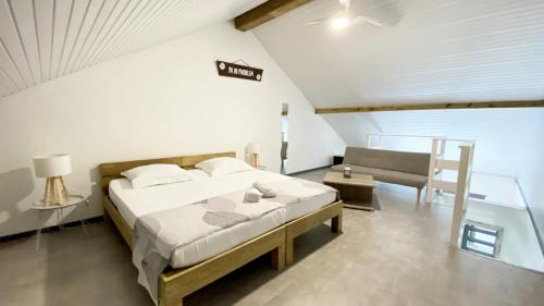 1 dormitorio con 1 cama y un banco en una habitación en Ti Caraïbes, appartement T3 atypique, vue mer, piscine et proche plage, en Les Trois-Îlets