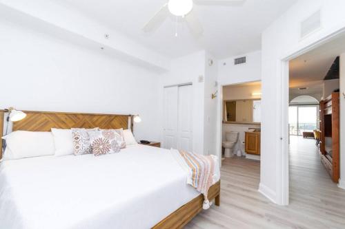 ein weißes Schlafzimmer mit einem großen Bett und einem Badezimmer in der Unterkunft Orlando Blue Heron condo 1 mile from Disney in Orlando