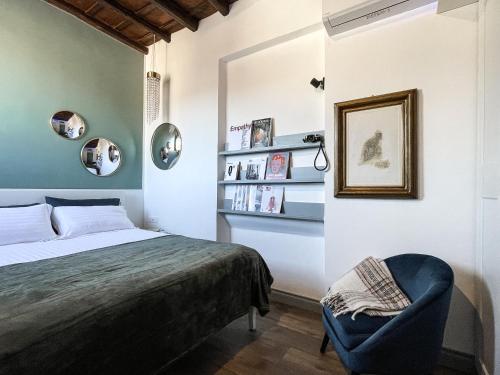 a bedroom with a bed and a chair and bookshelves at DomusLu' - Casa di charme nel cuore di Roma in Rome