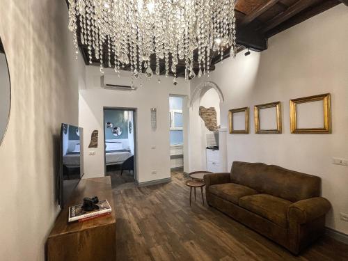 a living room with a couch and a chandelier at DomusLu' - Casa di charme nel cuore di Roma in Rome