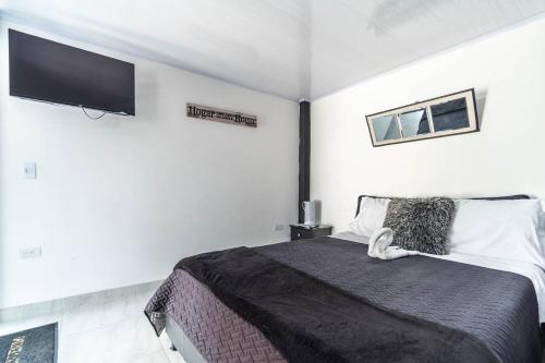 a bedroom with a bed and a flat screen tv at Edificio SantaMarta Medellín in Medellín