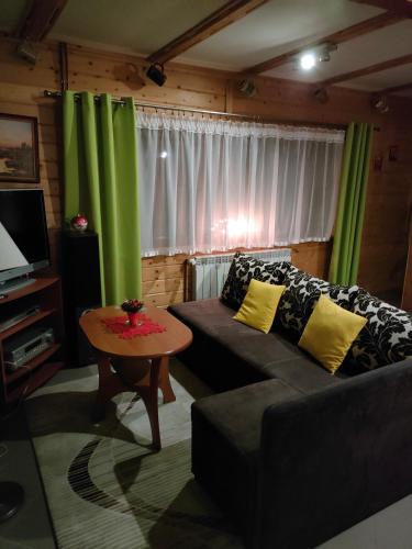 a living room with a couch and a table at Domek Domino in Korbielów