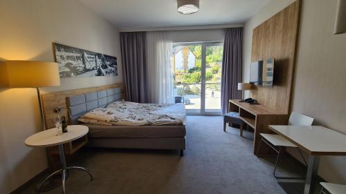a bedroom with a bed and a desk and a window at Apartament Panorama 123 Czarna Góra in Sienna