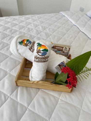 a tray with towels and flowers on a bed at AKUAIPPA HOSTAL RESTAURANT in Santa Marta