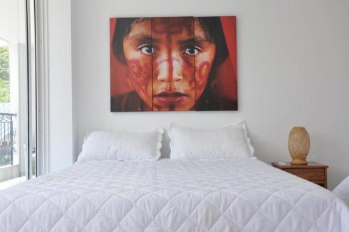 a bedroom with a large painting of a woman at AKUAIPPA HOSTAL RESTAURANT in Santa Marta