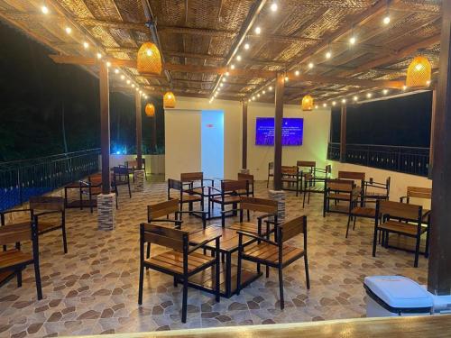 a restaurant with tables and chairs in a room at AKUAIPPA HOSTAL RESTAURANT in Santa Marta