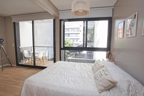 a bedroom with a white bed and a large window at Fancy 1BR Apartment in Nuñez in Buenos Aires