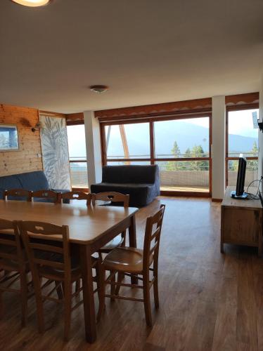 un salon avec une table, des chaises et un canapé dans l'établissement Les Villages du Bachat à Chamrousse 1700 -Silènes A32 - Classé 3 étoiles, à Chamrousse
