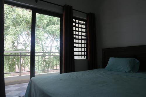 a bedroom with a bed and a large window at 3 Bedroom Family Pool Villa Flic-en-Flac Beach in Flic-en-Flac