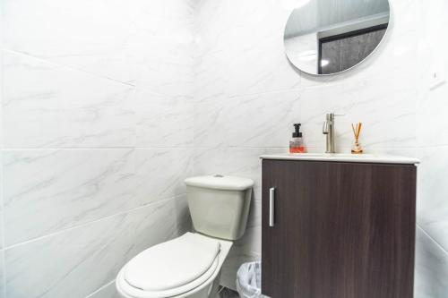 a bathroom with a toilet and a mirror at Edificio SantaMarta Medellín in Medellín