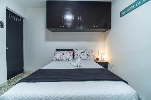 a bedroom with a bed with a black and white blanket at Edificio SantaMarta Medellín in Medellín