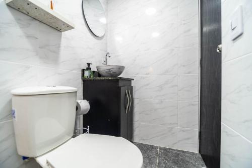 a white bathroom with a toilet and a sink at Edificio SantaMarta Medellín in Medellín