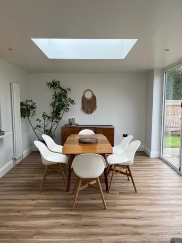 a dining room with a table and white chairs at The Old Gatehouse Luxury Cottage in Legbourne