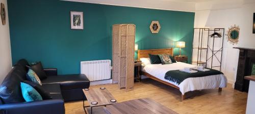 ein Schlafzimmer mit einem Bett, einem Stuhl und einem Sofa in der Unterkunft Leckhampton Road Apartments - Cheltenham in Cheltenham