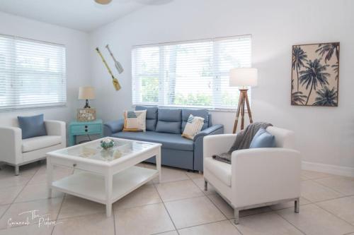 a living room with a blue couch and a table at Ultimate Group Escape - 8BD Oceanfront Beach House in Fort Pierce