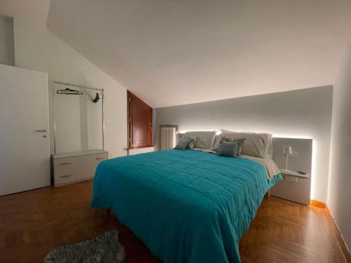 - une chambre avec un grand lit et une couverture bleue dans l'établissement LHE Maison Almerici, à Cesena