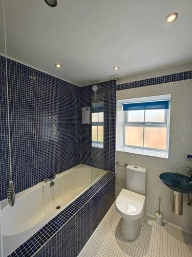 a bathroom with a tub and a toilet and a sink at The Castle in Killingworth