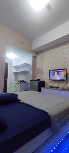 - une chambre avec un grand lit et une télévision murale dans l'établissement Goodroom apartement, à Padurenan