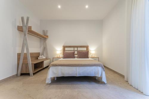 a white bedroom with a bed and a staircase at CMDreams Platinium- Apartamentos turísticos en el centro de Mérida in Merida