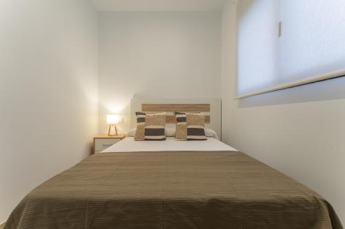 a bedroom with a large bed with a brown blanket at CMDreams Platinium- Apartamentos turísticos en el centro de Mérida in Merida