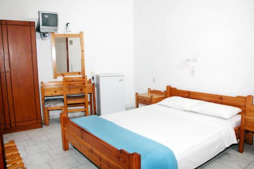 ein Schlafzimmer mit einem Bett und einem Fernseher in der Unterkunft Hotel Thisvi in Stalida