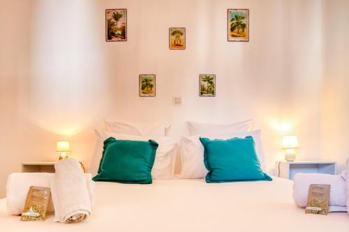 ein Schlafzimmer mit einem weißen Bett mit blauen Kissen in der Unterkunft Kaz d Heva in Saint-Pierre