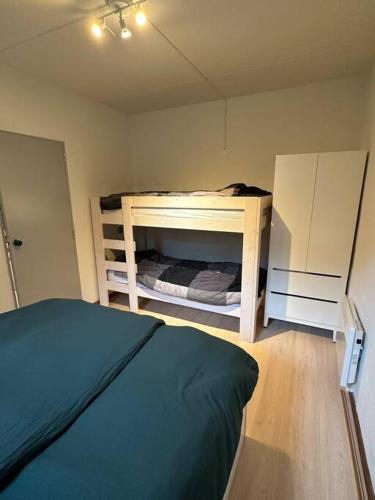 a bedroom with a bed and a bunk bed and a room with a bunk bed at Le Papillon in Hotton