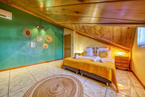 sypialnia z łóżkiem i zieloną ścianą w obiekcie Kaz Latania w mieście Étang-Salé