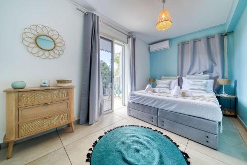 a blue bedroom with a bed and a large window at Kaz d Abord in Saint-Pierre