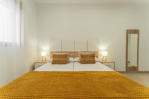 a bedroom with a large bed with two lamps at CMDreams Platinium- Apartamentos turísticos en el centro de Mérida in Merida