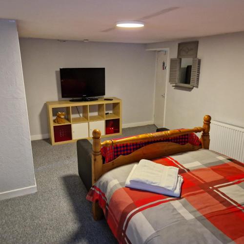 a bedroom with a bed and a flat screen tv at Hide away (Central Inverurie) in Inverurie