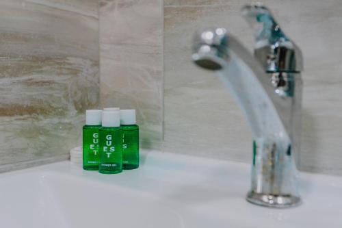 a bathroom sink with a green bottle next to a faucet at Madina-ZamZam Halal Hotels Group in Baku