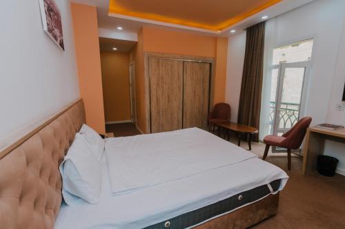a hotel room with a bed and a desk at Madina-ZamZam Halal Hotels Group in Baku