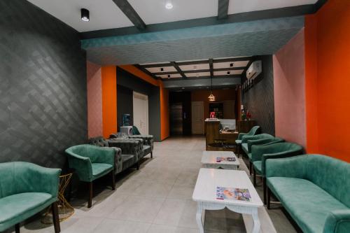 a waiting room with green chairs and tables at Madina-ZamZam Halal Hotels Group in Baku