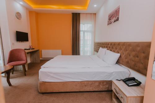 um quarto com uma cama, uma secretária e uma televisão em Madinah Hotel em Baku